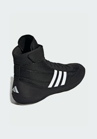 Černá sportovní bota s vysokým designem. Disponuje síťovinovým materiálem, třemi bílými diagonálními pruhy a suchým zipem pro podporu kotníku.