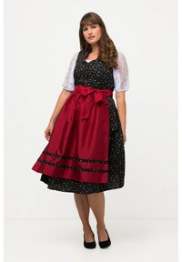 Robe noire avec un motif floral, manches en dentelle blanche, tablier rouge et ceinture assortie nouée. Elle présente un ourlet évasé et des rayures horizontales.