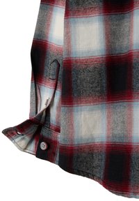 Camisa de cuadros con patrones en rojo, negro y azul. Hecha de un tejido de textura suave, incluye un detalle de botón y un lazo.