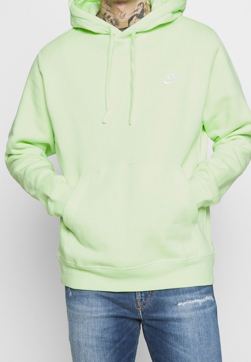 Limegrön hoodie med en känguruficka, dragsko-huva och liten vit Nike-logga på bröstet. Mjukt tyg med en slät yta.
