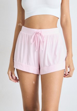 Shorts de sport rose en tissu lisse, avec une taille élastique équipée d'un cordon de serrage et des ourlets roulés pour une coupe décontractée.