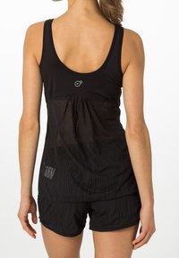 Top deportivo negro sin mangas con un panel de malla en la parte posterior, que presenta un escote redondeado y un logotipo sutil. Combinado con pantalones cortos a juego.