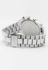 Silverfärgad klocka i rostfritt stål med länkdesign. Har en rund boett och en polerad stålfinish som visar en minimalistisk estetik.