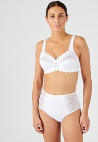 Conjunto de lencería blanca que incluye un bralette con acentos de encaje y braguitas de talle alto. Tejido suave, detalles de encaje floral en los laterales.