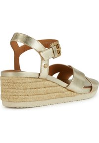 Sandalo wedge in pelle dorata con nastri incrociati e fibbia regolabile. Texture della suola intermedia avvolta in juta e suola in gomma per una buona aderenza.