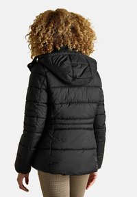 Must haakidega must puffer jakk, millel on horisontaalne õmblus, tõmblukk ja nööbid. Sujuv tekstuur, keskmise pikkusega lõige.