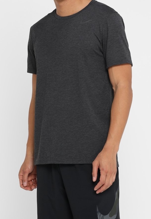 Camiseta de manga corta gris oscuro, hecha de una tela suave, con un escote redondo y un logo sutil en la parte superior izquierda.