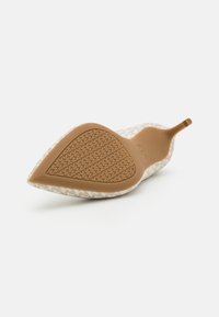 Beige vzorované boty na nízkém podpatku s špičatou špičkou a flexibilní gumovou podrážkou. Podrážka má strukturovaný vzor pro lepší přilnavost.