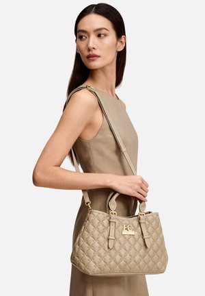 Borsa trapuntata beige in materiale sintetico con ferramenta dorata, doppio manico e tracolla regolabile. Presenta un logo impresso sul davanti.