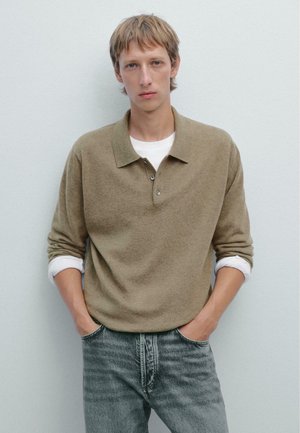 Bruine lange mouwen polo-shirt met een zachte textuur, drie knopen aan de kraag en iets opgerolde mouwen, gecombineerd met lichte spijkerbroek.