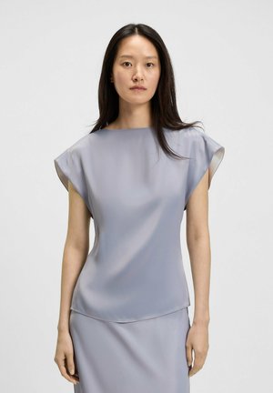 Top grigio chiaro a maniche corte con una texture liscia e setosa e scollatura a barca. Presenta una vestibilità rilassata e maniche leggermente svasate.