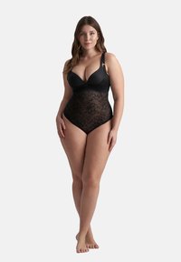 Body nero con top imbottito, motivo in pizzo floreale nella parte inferiore e spalline regolabili con dettagli in ottone dorato.