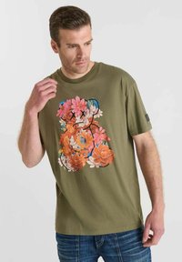 Camiseta de algodón en verde oliva con un vibrante estampado floral en rosa, naranja y blanco, con cuello redondo y mangas cortas.