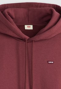 Maroon hoodie made from soft fabric. Features a kangaroo pocket, drawstring hood, and a small embroidered Levi's logo on the chest.