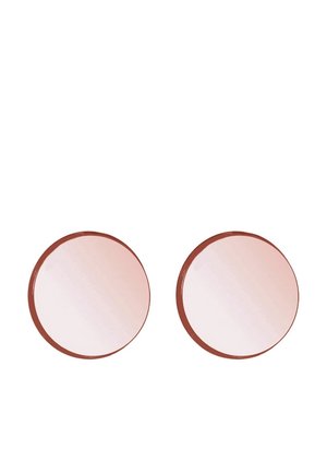 Deux miroirs de maquillage ronds avec cadre en or rose et surfaces légèrement réfléchissantes sur fond blanc uni.
