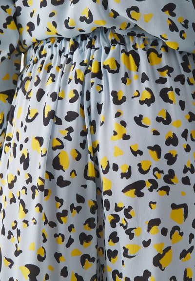 Tasă de textil de culoare albastră deschisă, cu o textură moale, prezintă un model îndrăzneț de imprimeu de leopard în culori negru și galben și o talie elastică.