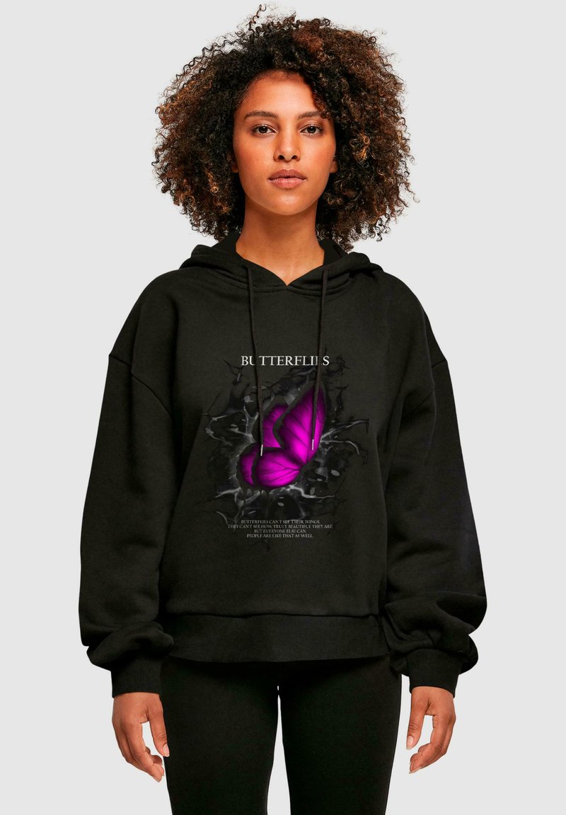 Felpa nera con un grafico di una farfalla viola su un design di muro crepato. Materiale morbido con un fit rilassato e cappuccio con cordino regolabile.