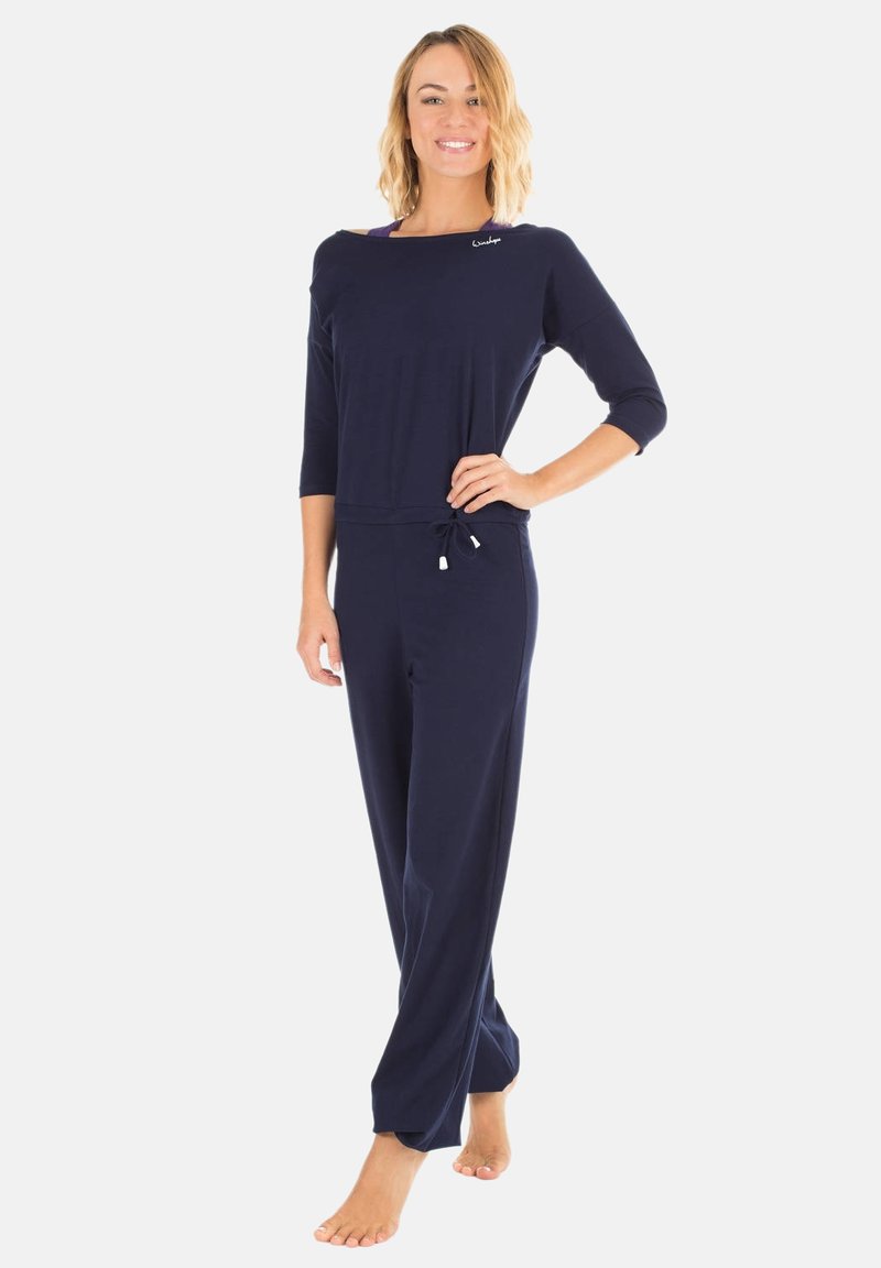 Combinaison bleu marine en tissu doux, avec un col rond, des manches trois-quarts, une taille à cordon et des jambes droites.