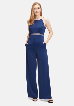 Marineblauer Overall mit tailliertem Oberteil, transparentem Ausschnitt in der Taille, weitem Beinschnitt und seitlichen Taschen. Glattes Gewebe mit minimaler Textur.
