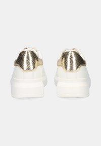 Zapatillas blancas con un acento en el talón de piel de pitón texturizada en color dorado, suela acolchada y parte superior lisa con una forma redondeada.