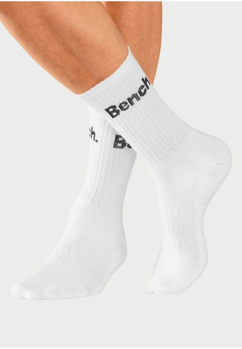 Weiße Socken mit geripptem Textil und schwarzem "Bench."-Logo, das an den Seiten aufgedruckt ist. Die Socken sind knöchellang und zeigen ein schlichtes Design.