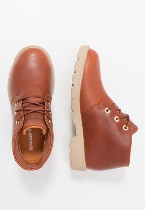 Paire de bottines en cuir marron avec semelles en caoutchouc beige et lacets, vues de dessus et de côté sur fond blanc.