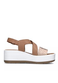 Sandal in pelle sintetica marrone con fasce incrociate, dettaglio metallico texturizzato, suola piatta bianca con dettagli rigati e cinturino alla caviglia regolabile.