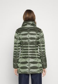 Green padded jacket with a high collar, featuring a shiny, smooth texture and horizontal quilted design, extending to mid-thigh length.