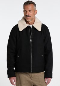 Black wool-blend jacket with a cream-colored faux shearling collar, zipper front, and side pockets. Features a relaxed fit and sturdy fabric.