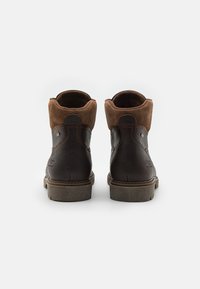 Botas de tobillo de cuero marrón y ante con un acabado texturizado, punta redondeada y suela de goma, que cuentan con detalles de costura y un cuello acolchado.