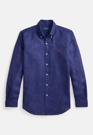 Chemise en lin bleu marine à manches longues avec col boutonné, patte de boutonnage à l'avant et petit logo brodé rouge sur la poitrine gauche.