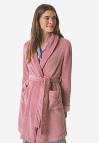 Różowy szlafrok zfleece o szalowym kołnierzu, wiązaniu w talii i dwóch przednich kieszeniach. Posiada teksturowaną tkaninę i wzorzyste mankiety.