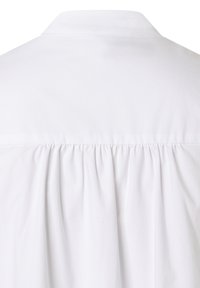 Weißes Hemd mit klassischem Kragen, gathered Detail am Rücken und einer glatten, leichten Stoffstruktur.