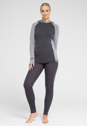Langærmet hættebluse i mørkegrå med lysegrå ærmer og detaljer, parret med mørkegrå leggings. Stof ser glat ud med tætsiddende design.