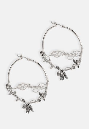 Silver hoop earrings with a floral design, featuring embossed roses and the name "Ed Hardy" integrated into the shape. Textured accents.
