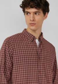 Karierte Hemdjacke in Dunkelrot mit weißen Linien, ausgestattet mit einem Kragen, einer Brusttasche und strukturiertem Stoff.