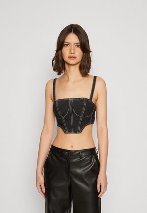Schwarzes Denim-Cropped-Top mit dünnen Trägern, das strukturierte Nähte und einen quadratischen Ausschnitt aufweist, kontrastiert durch weiße Stickdetails.