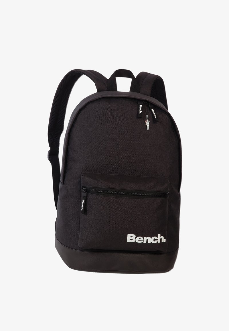 Black fabric backpack with padded straps, front zip pocket, and a large main compartment. Features "Bench." logo in white on the front.
