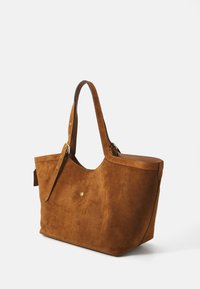 Borsa a tracolla in suede marrone con manici in pelle, caratterizzata da un design minimalista e da una sottile embellishment dorata sul davanti.