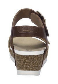 Braune Ledersandale mit verstellbarem Riemen, korkähnlichem Keilabsatz, weißer Sohle und strukturiertem Fußbett. Mit Branding auf der Rückseite.