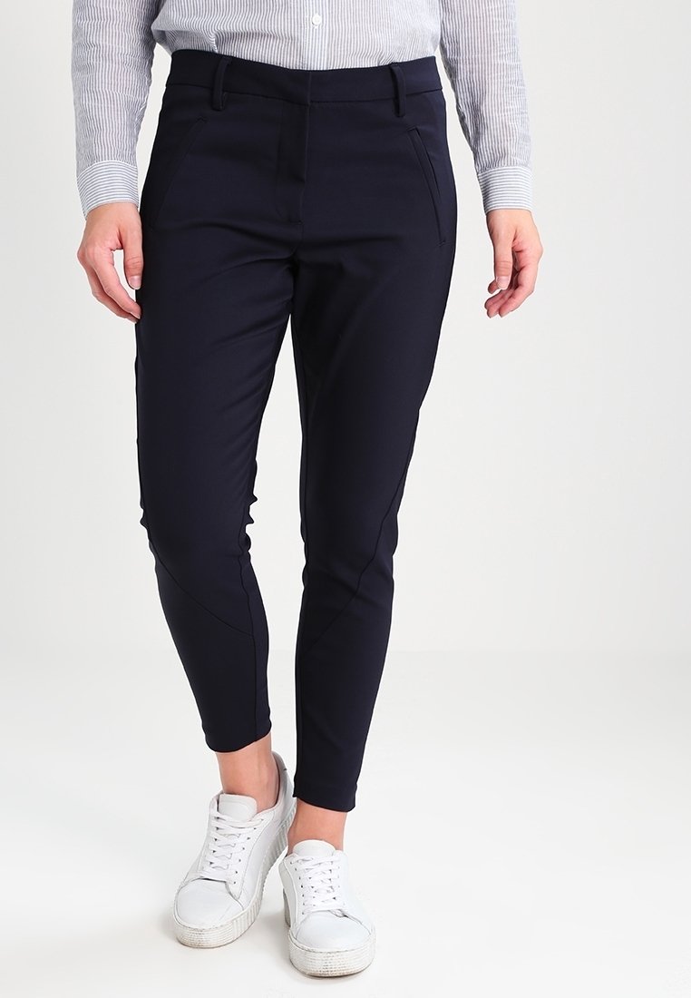 Námořnické zúžené kalhoty vyrobené z elastického materiálu. Mají šikmé boční kapsy a hladký přední díl. V kombinaci s bílými nízkými teniskami.