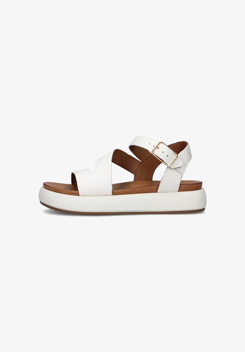 Sandali bianchi in pelle con design a strappo incrociato, chiusura con fibbia e una suola spessa bianca con soletta marrone per un'ammortizzazione ottimale.