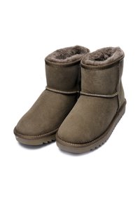 Botas de tobillo de ante marrón con forro de piel suave, puntera redonda, costuras expuestas y suela de goma resistente con un patrón de agarre texturizado.