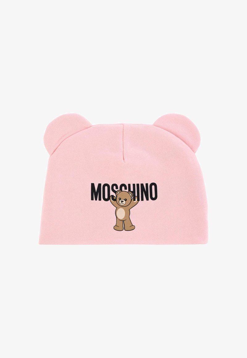 Bonnet en tricot rose avec des accents pour les oreilles et un motif de dessin animé représentant un ours tenant le mot "MOSCHINO" en texte noir. Texture douce, forme arrondie.
