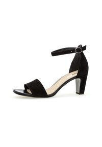 Sandale à talons hauts en velours noir avec bout ouvert, sangle de cheville avec boucle, et un talon bloc noir brillant. Intérieur lisse avec semelle intérieure beige.