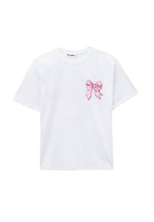 T-shirt bianca a maniche corte con una piccola grafica a forma di fiocco rosa sul petto sinistro e scollo rotondo.