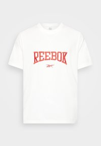 Vit bomull t-shirt med en stor röd "REEBOK" logotyp över bröstet. Korta ärmar och en klassisk rund halsringning.