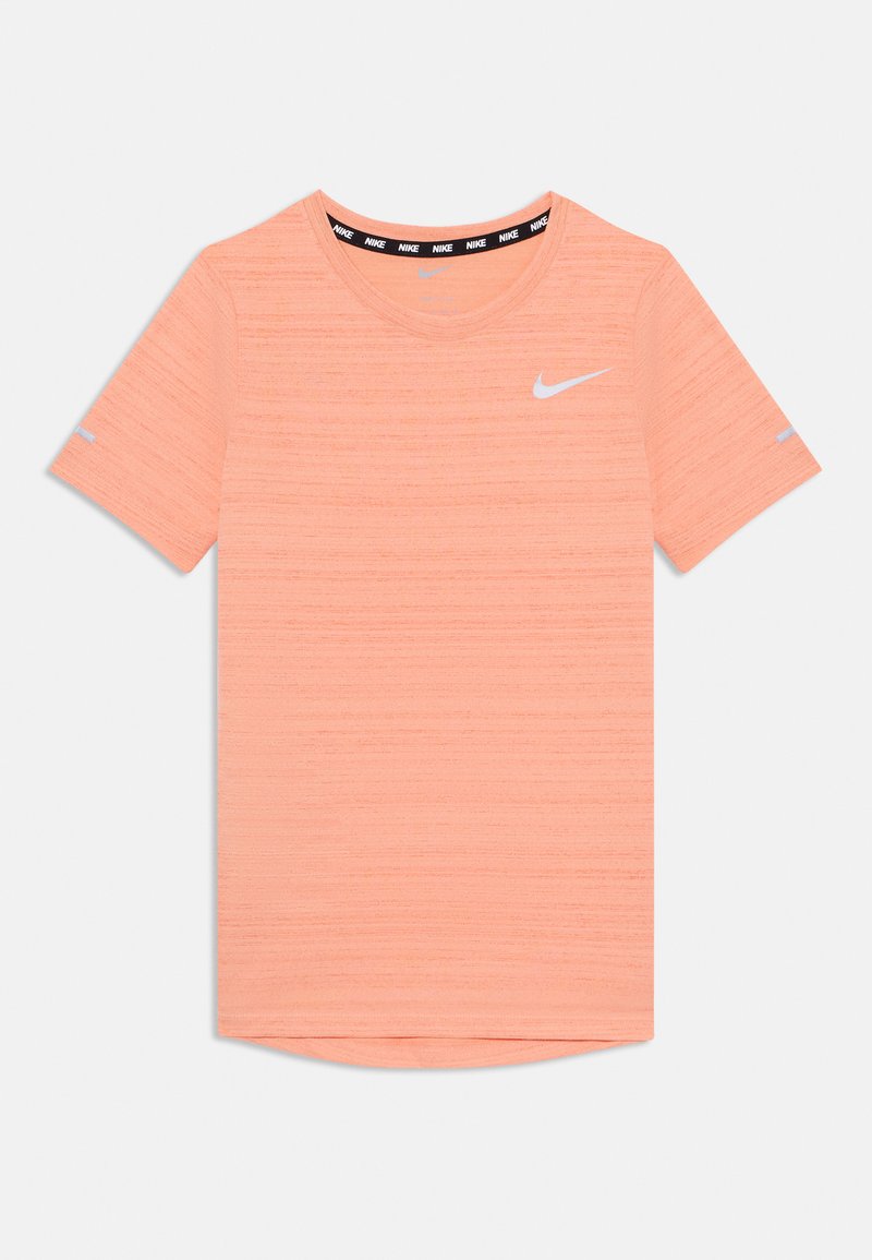 Camiseta deportiva de manga corta en coral claro, con tejido texturizado, cuello redondo y logo de Nike en blanco en el pecho.