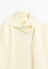 Zachte, crèmekleurige sjaal met een gladde textuur en gedrapeerd ontwerp, met een elegante gedraaide vorm bij het nekgebied.