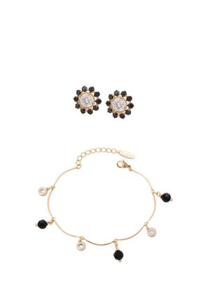 Brățară aurie cu talismane rotunde negre și transparente alternate, asortată cu cercei aurii cu șuruburi, având centre transparente înconjurate de pietre negre.